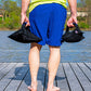 Person standing on dock holding two Shotbag Ballast weights by the handle, facing water